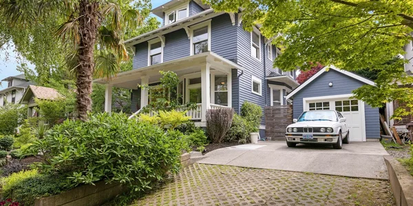 Blue Victorian foursquare with white car in driveway